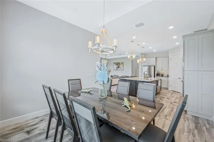 Dining room with a chandelier, light wood finished floors, and recessed lighting