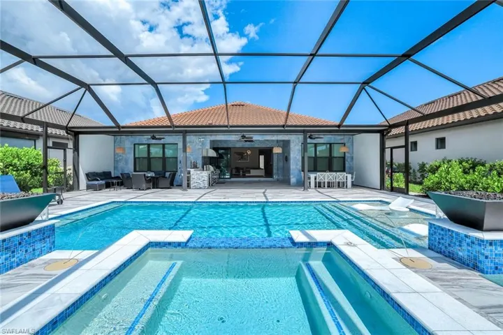 View of swimming pool featuring a ceiling fan, a pool with connected hot tub, an outdoor living space, and a patio area