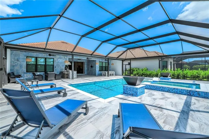 View of pool with ceiling fan, a patio, a pool with connected hot tub, an outdoor living space, and glass enclosure