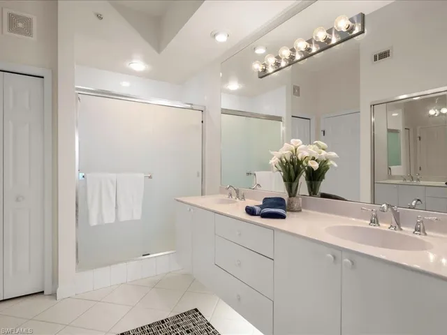 Bathroom featuring a closet, a shower stall, light tile patterned flooring, and recessed lighting