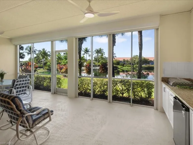 Sunroom featuring a water view and a textured ceiling