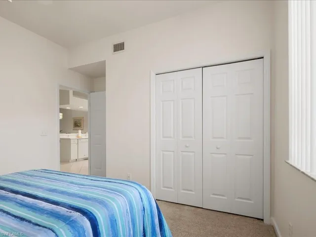 Bedroom featuring light carpet and a closet