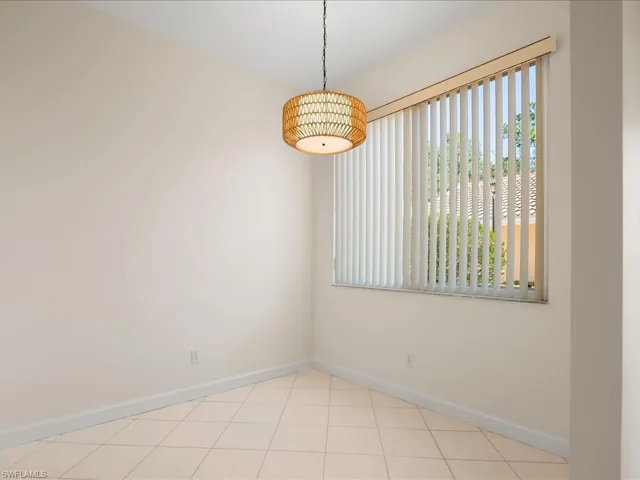 Spare room with baseboards and light tile patterned flooring