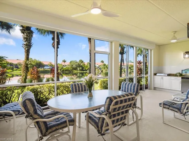 Sunroom / solarium with carpet, a textured ceiling, and a water view