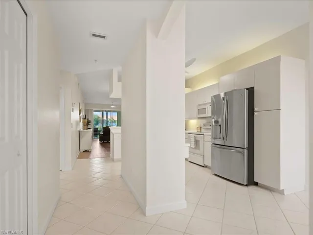 Hallway featuring light tile patterned floors and baseboards