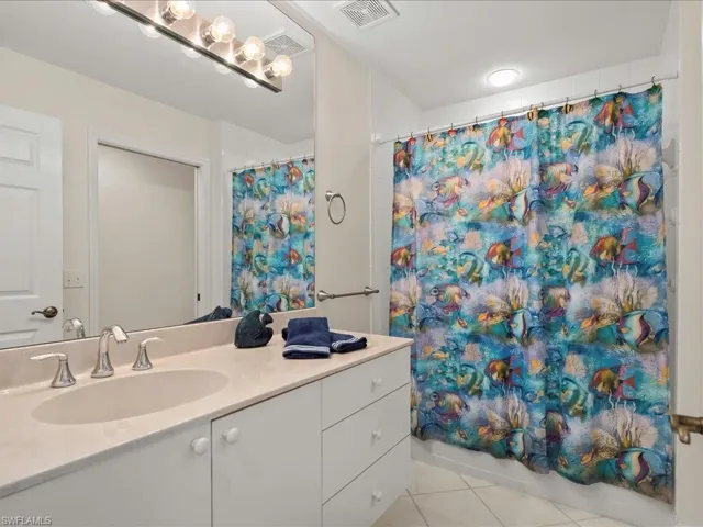 Bathroom featuring light tile patterned flooring, vanity, and shower / bath combo