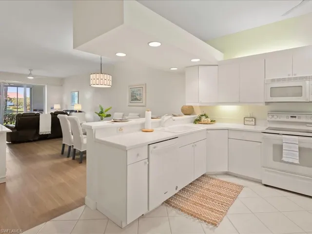 Kitchen with ceiling fan, white appliances, open floor plan, recessed lighting, and white cabinetry