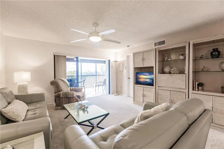 Living area with carpet floors, a textured ceiling, and ceiling fan