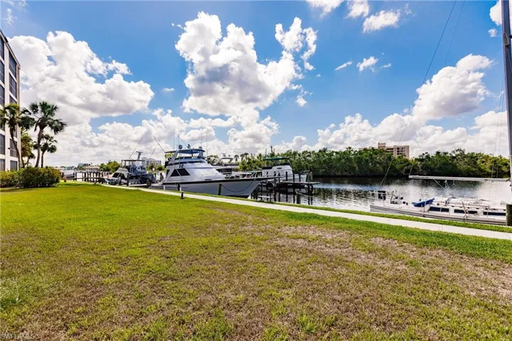 Dock area with a yard and a water view
