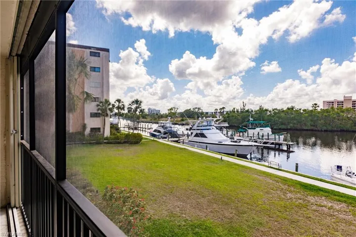 Dock area featuring a water view, a yard, and a sunroom