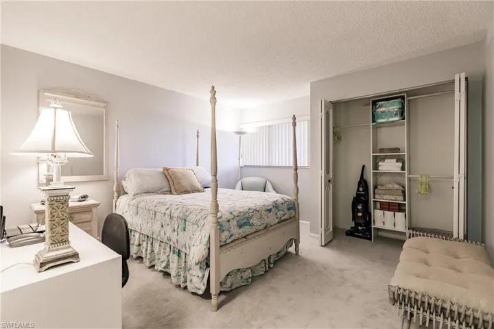 Carpeted bedroom with a closet and a textured ceiling