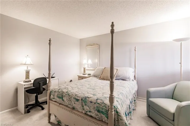 Bedroom featuring a textured ceiling and light carpet