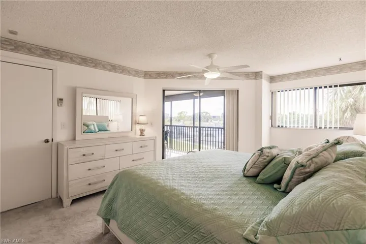 Bedroom featuring access to outside, carpet flooring, a textured ceiling, and ceiling fan