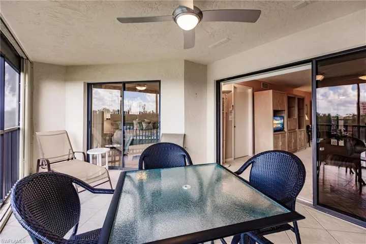 Sunroom with healthy amount of natural light, outdoor dining space, and ceiling fan