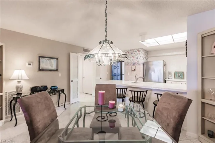 Dining room featuring a chandelier, built in shelves, light tile patterned floors, and a textured ceiling