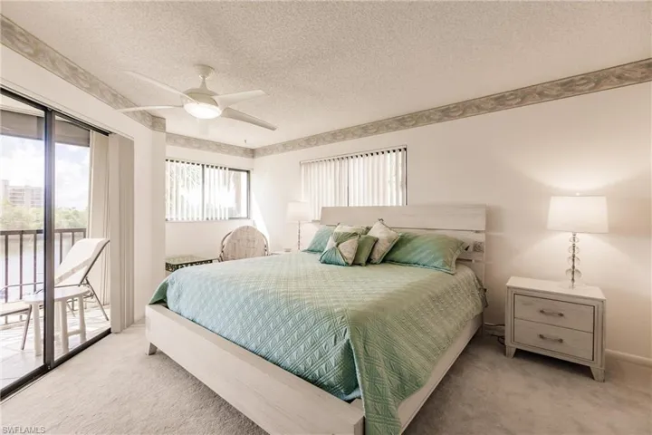 Bedroom with access to outside, a textured ceiling, light carpet, and ceiling fan