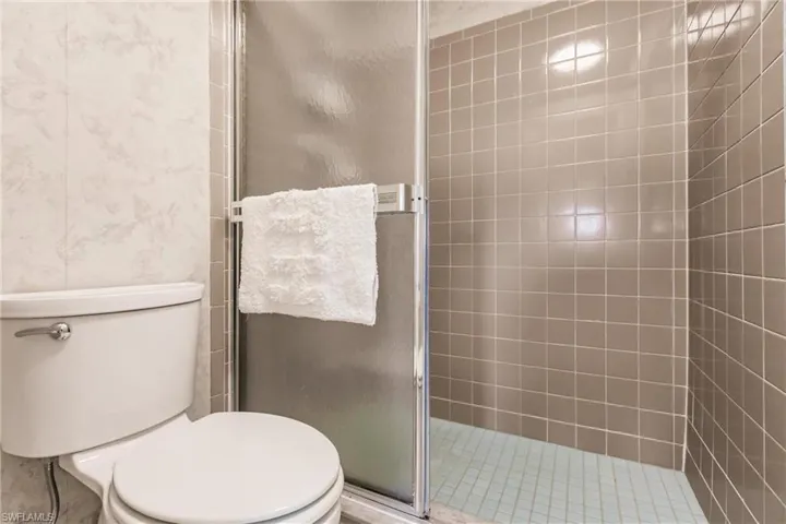 Full bathroom featuring a stall shower and toilet