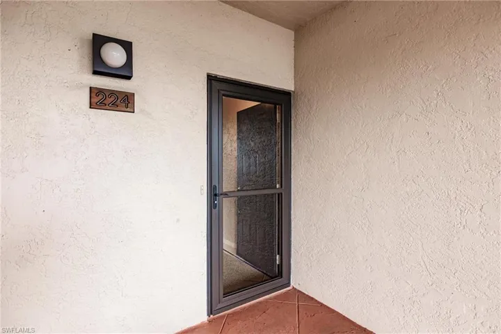 Doorway to property featuring stucco siding