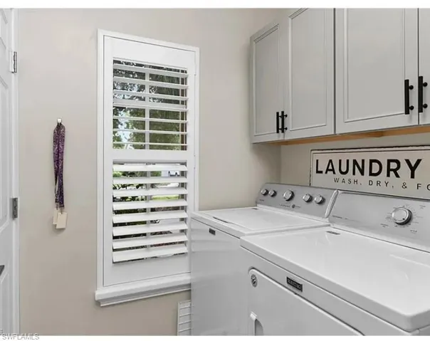 Laundry area featuring washing machine and dryer and cabinet space