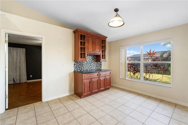 Kitchen featuring backsplash and light tile patterned floors