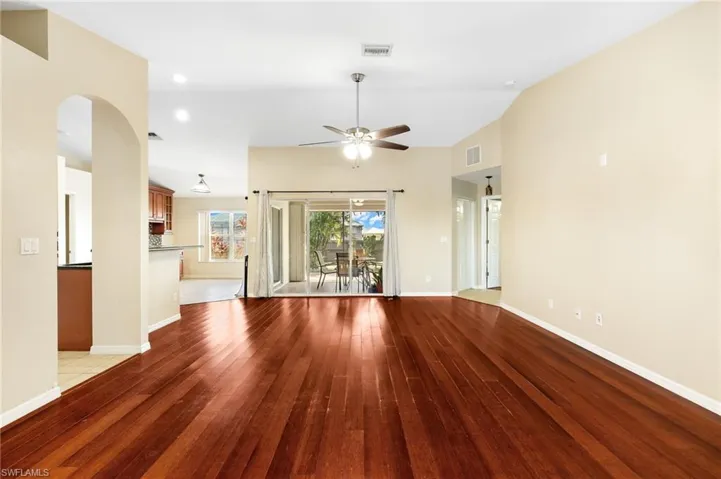 Unfurnished living room featuring light hardwood / wood-style flooring, ceiling fan, and lofted ceiling