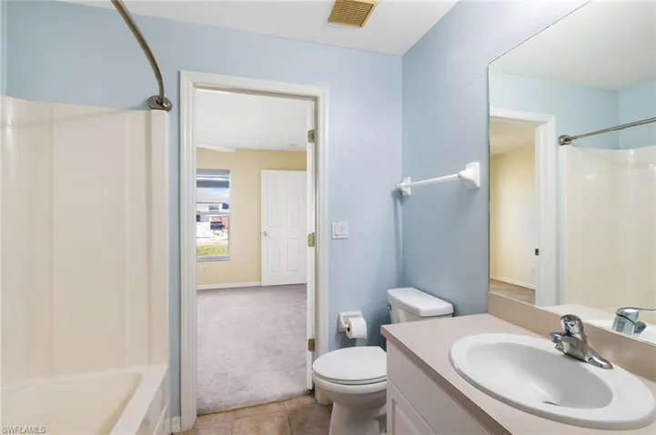 Full bathroom featuring toilet, bathtub / shower combination, vanity, and tile patterned floors