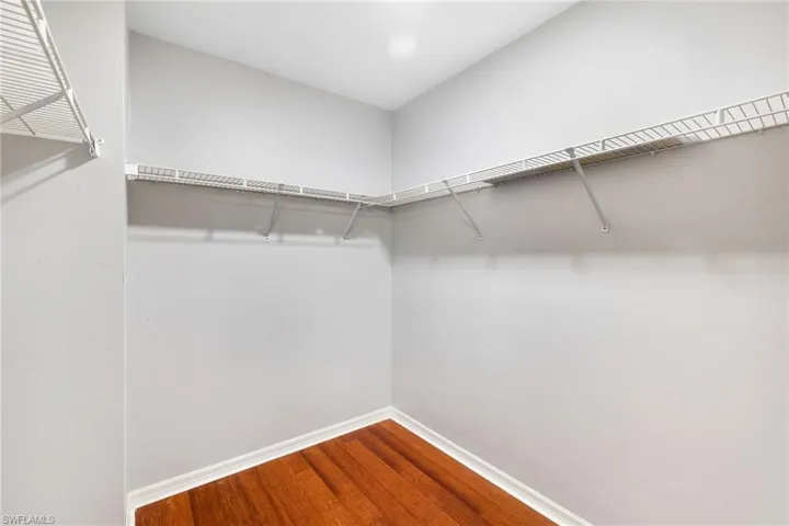Spacious closet with hardwood / wood-style flooring