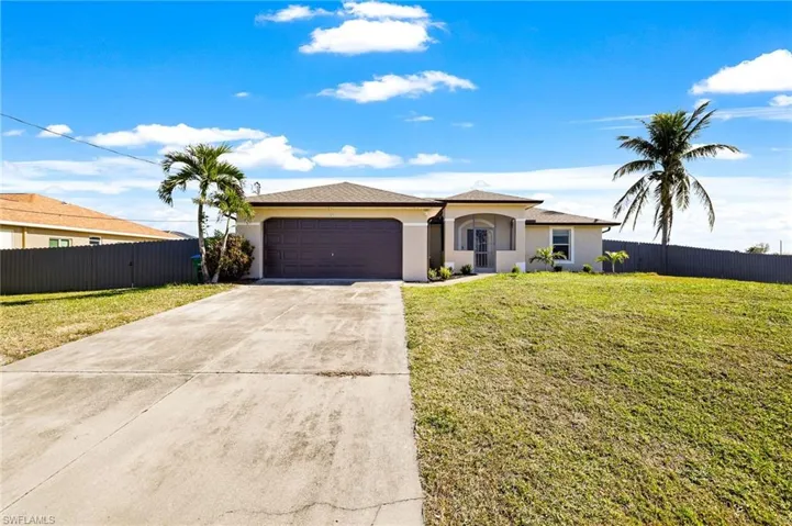 Ranch-style house with a garage and a front lawn