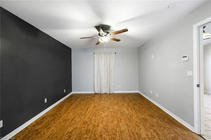 Empty room with ceiling fan and wood-type flooring