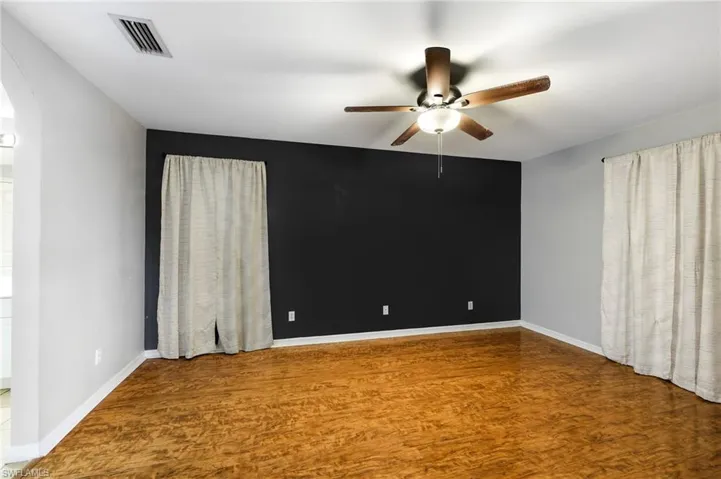 Empty room featuring ceiling fan and hardwood / wood-style flooring