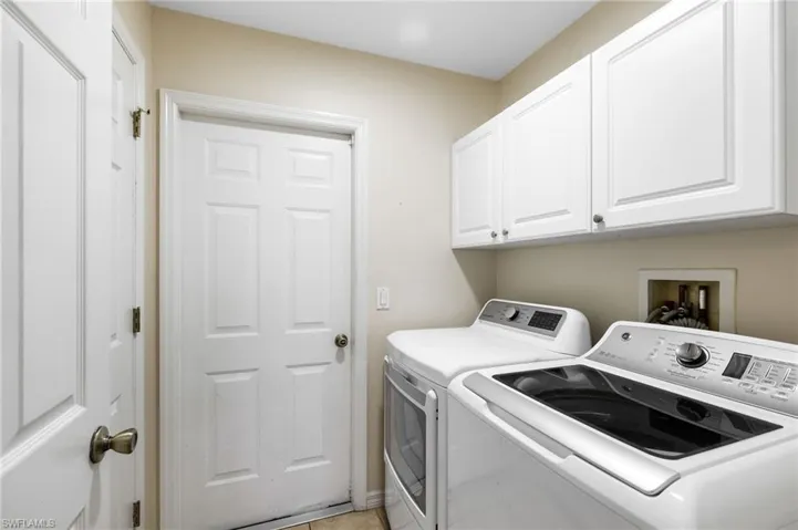 Clothes washing area with washer and dryer and cabinets