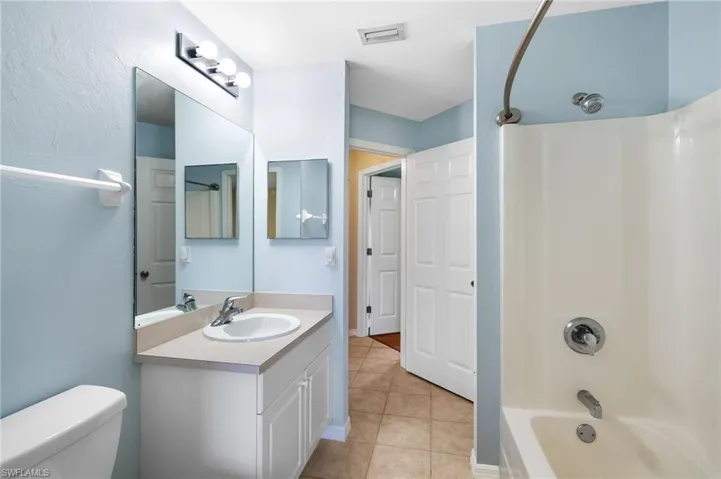 Full bathroom with tile patterned floors, vanity,  shower combination, and toilet