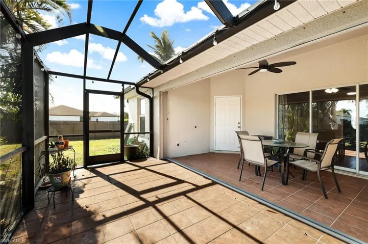 Sunroom / solarium with vaulted ceiling with beams, ceiling fan, and a healthy amount of sunlight