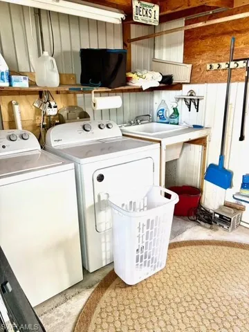 Laundry room with washer and clothes dryer and concrete flooring