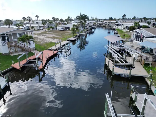 Dock area featuring boat lift, a water view, and a residential view