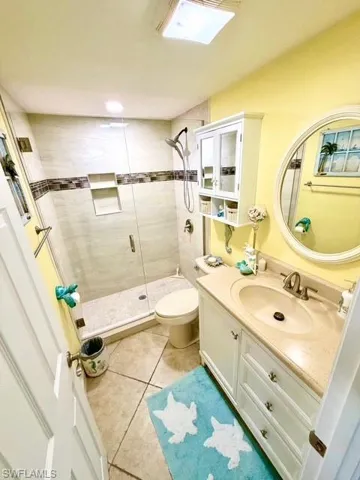 Bathroom featuring vanity, a shower stall, and light tile patterned floors