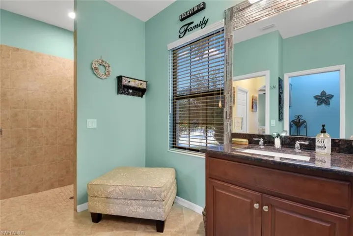 Full bath with vanity, tile patterned floors, and a walk in shower
