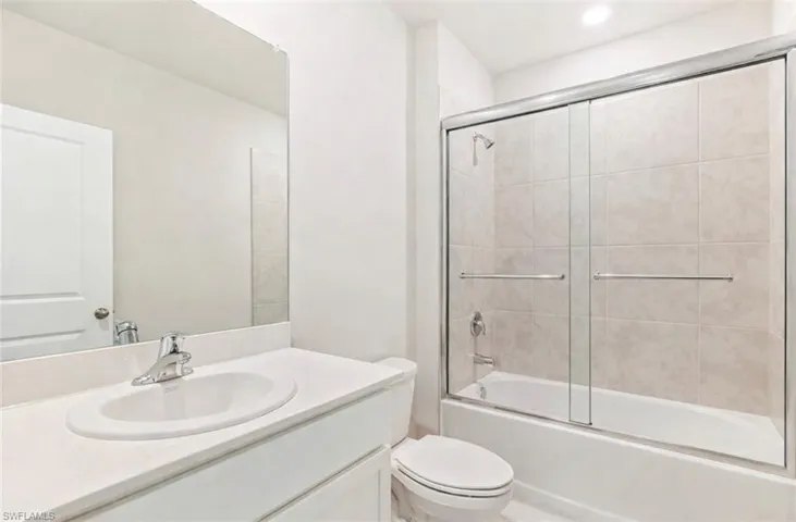 Full bath with vanity and bath / shower combo with glass door