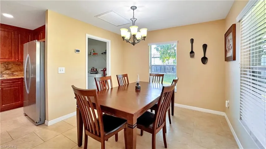 Tiled dining area featuring an inviting chandelier
