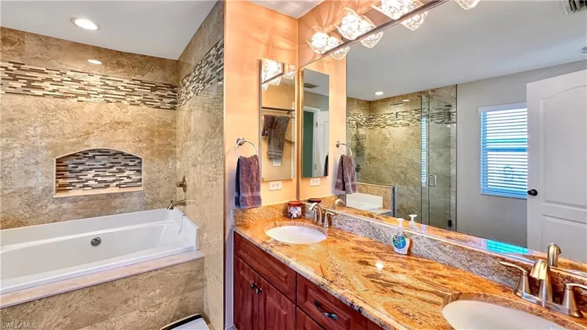 Bathroom with double sink vanity and separate shower and tub
