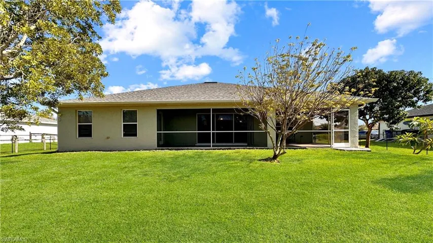 Back of house with a yard