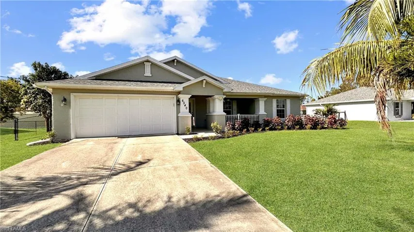 View of front of house with a garage and a front yard