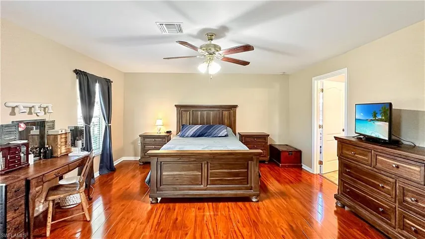 Bedroom featuring ceiling fan and dark wood-type flooring