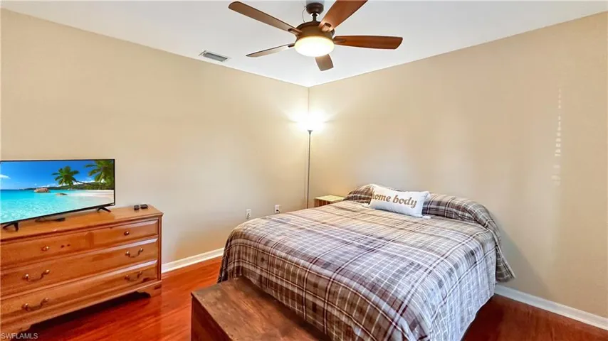 Bedroom with dark hardwood / wood-style floors and ceiling fan