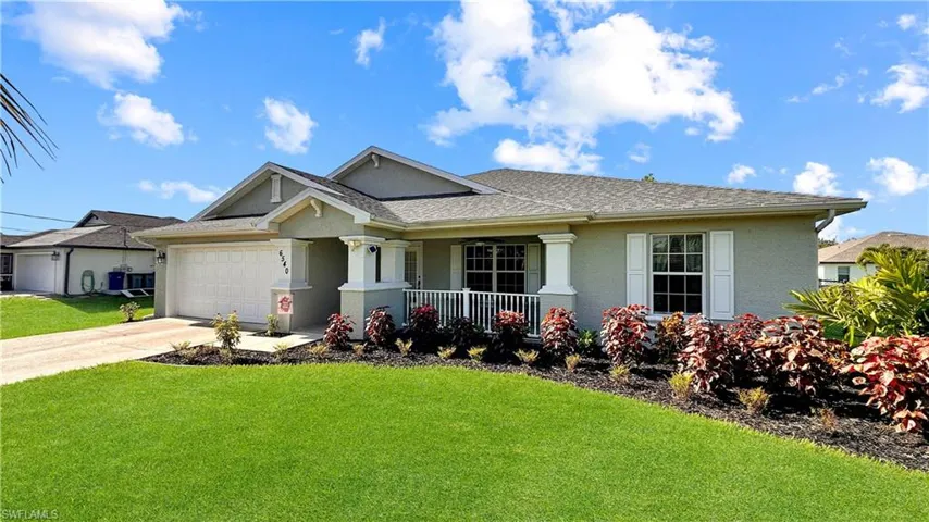 View of front facade with a garage and a front lawn