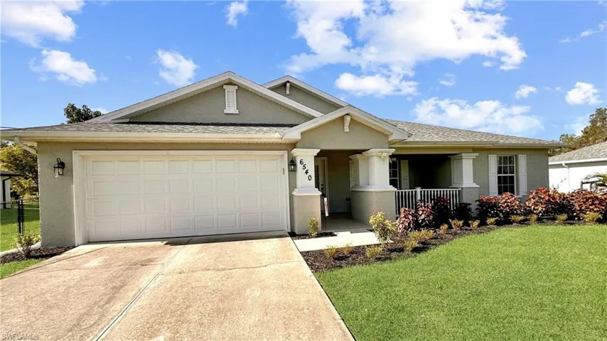 View of front facade featuring a front yard and a garage