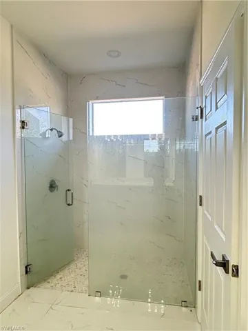 Bathroom featuring a marble finish shower