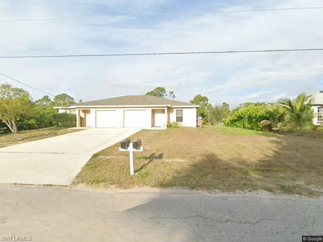 Single story home with a front yard and concrete driveway