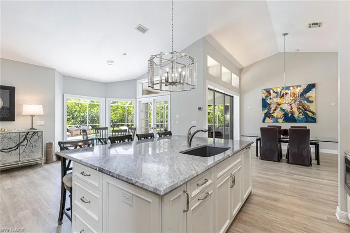 Spacious kitchen island featuring a deep undermount sink, ample cabinetry, and an elegant pendant light fixture