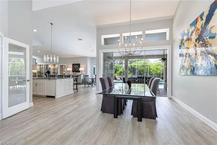Spacious open-concept interior with light wood-finish flooring and high vaulted ceilings